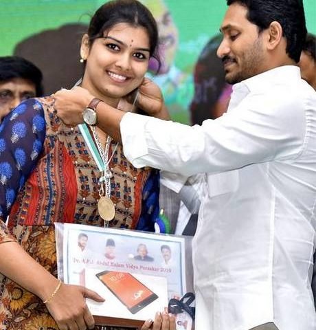 Chief Minister Y. S. Jagan Mohan Reddy presenting a medal to a girl at a programme held to mark National Education and Minorities Welfare Day, in Vijayawada on Monday.