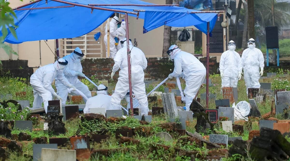 Health workers bury the body of a 12-year-old Nipah virus victim, at Kannamparambu cemetery in Kozhikode